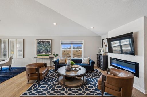 This spacious and open main level seamlessly connects to the dining area, perfect for entertaining. It also features many large windows providing abundant natural light. (Photo of a decorated model, actual homes finishes will vary)