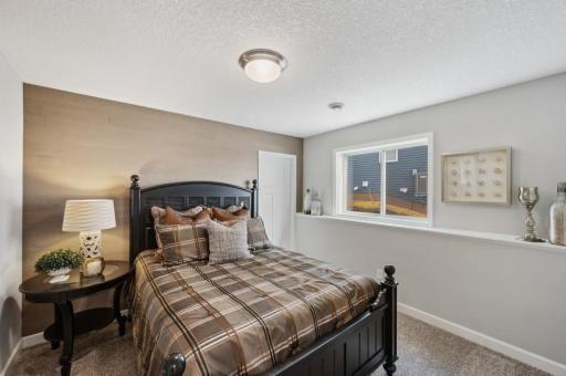 The fourth bedroom located on the lower level. (Photo of a decorated model, actual homes finishes will vary)