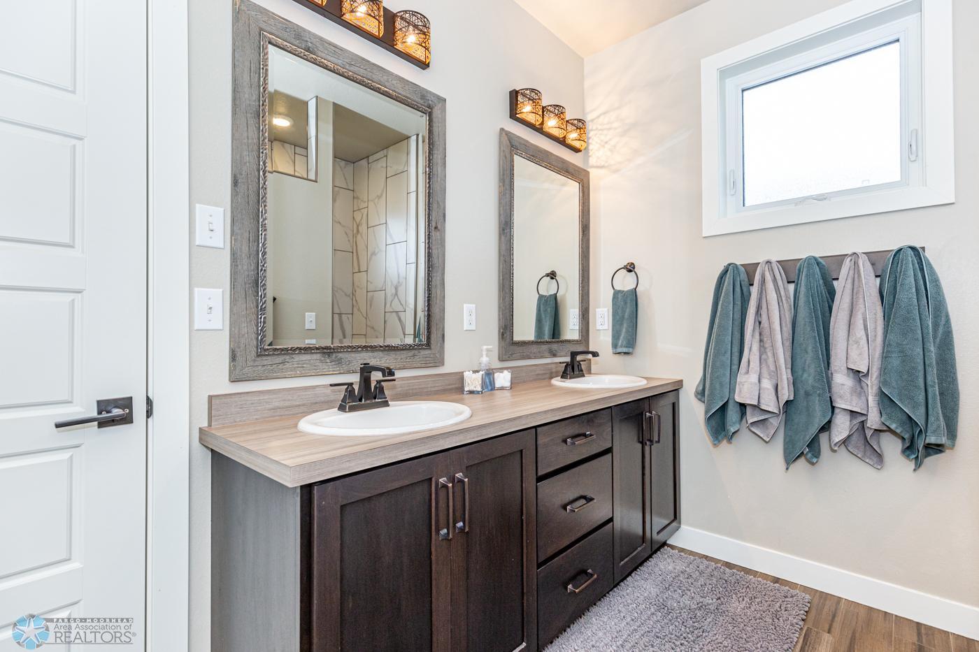 Primary Bathroom with 2 sinks, tile floor, tile shower, water closet and towel closet