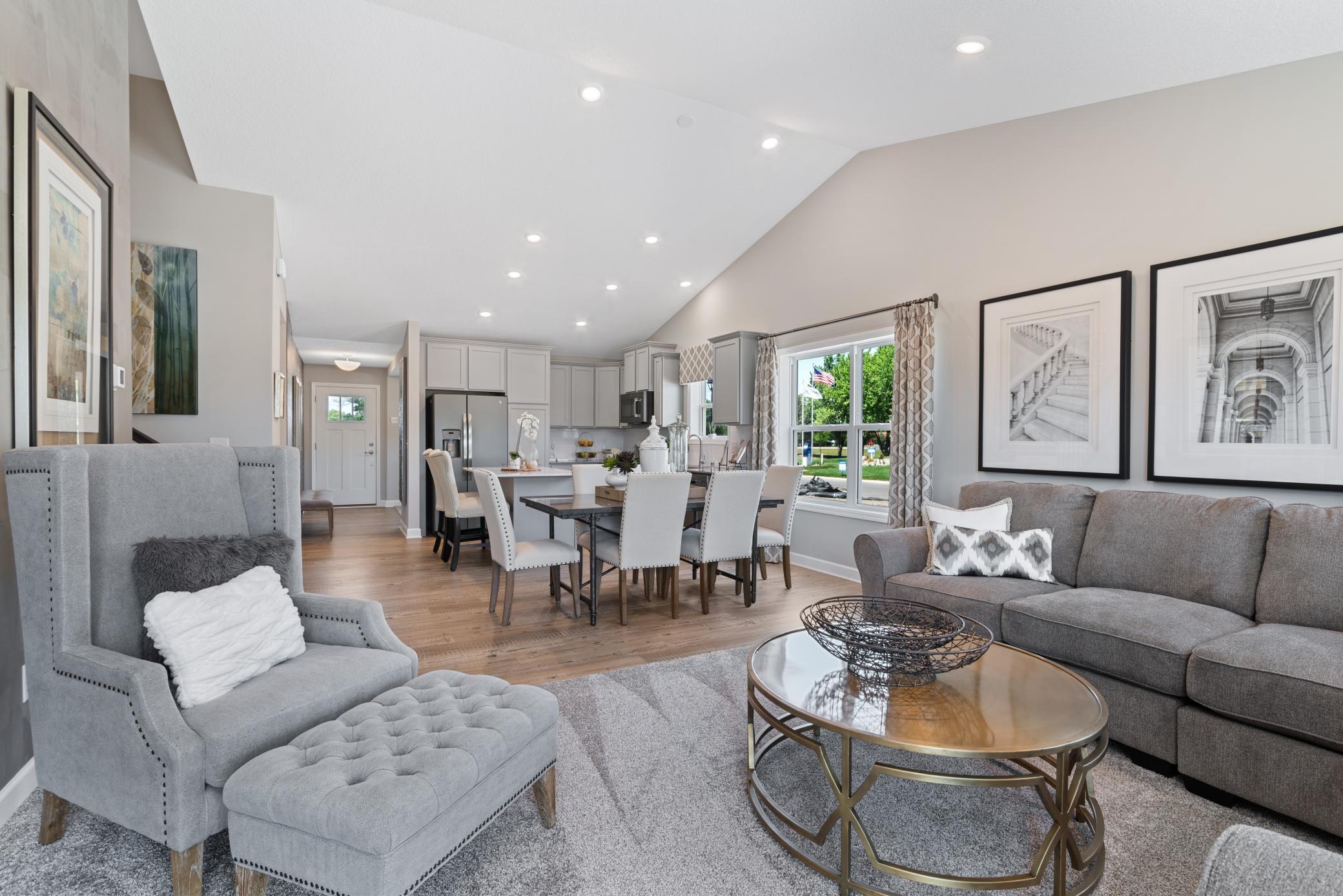 Welcome to the Courtland II where the gathering area seamlessly connects to the kitchen area, perfect for entertaining. It features many large windows providing warm natural light. (Photo of decorated model, actual home's finishes vary.)