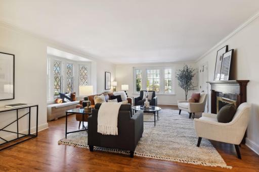Large living room accommodates multiple seating areas. Pretty, wood-burning, fireplace