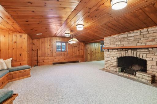 Let's talk about the paneling, the expansive wood-burning fireplace, stone and more