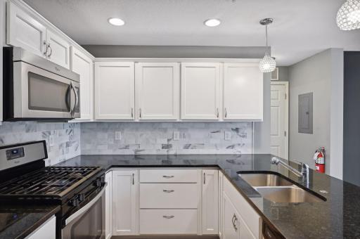 Granite counters, stainless appliances, tiled backsplash