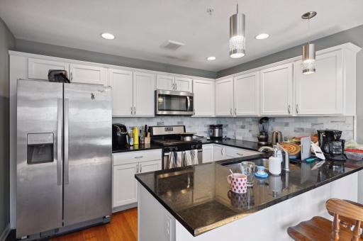 Kitchen with granite, SS appliances, tiled backsplash