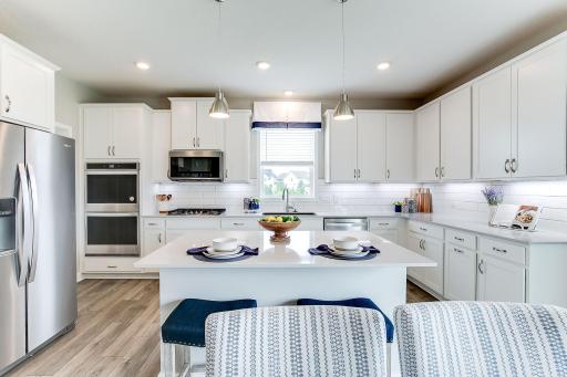 Welcome Home! Well-appointed kitchen with tile back splash, quartz countertops, walk-in pantry and more! *Photo of model home; same floor plan; colors and options may vary.