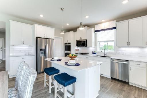 Featured in this home is the Signature kitchen package. True built-in double wall ovens (wifi) + drop in gas cooktop, microwave vented to the outside. Refrigerator is optional. *Photo of model home, same floor plan; colors and options may vary.