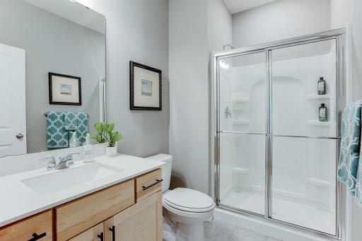 Main level bath with shower. *Photo of model home, same floor plan; colors and options may vary.