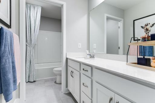 Upper-level hall bath with door separating the shower from the vanity. A major convenience in a busy household. *Photo of model home, same floor plan; colors and options may vary.