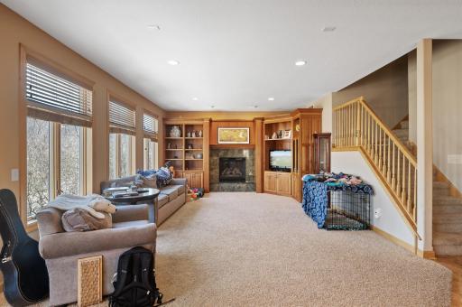 Unwind in the spacious family room featuring an open layout, 9-foot ceilings throughout the main level, a cozy gas-burning fireplace, and built-in entertainment nooks, ideal for cozy nights in or lively gatherings.