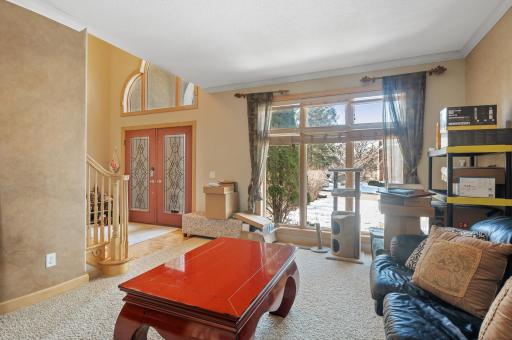 Entertain guests in the formal living room offering tranquil front yard views and seamless access to the inviting four-season porch featuring tasteful tile floors and a convenient deck entrance.