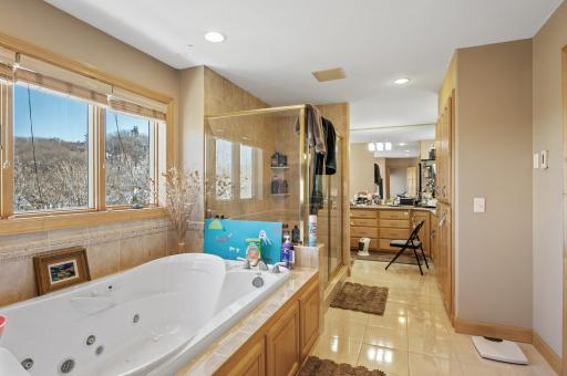Private bathroom is complete with tile floors, a jetted soaking tub, dual sinks and a walk-in shower for ultimate relaxation.