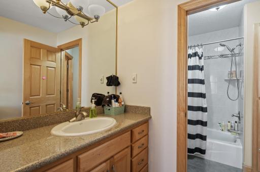 Jack-and-jill bathroom featuring a tub/shower combo and private vanity rooms.