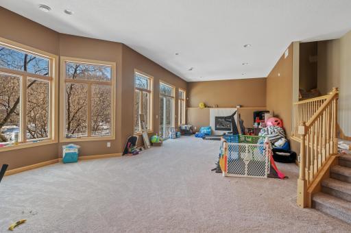 Entertain effortlessly in the massive walk-out lower level family room boasting abundant natural light, 11-foot ceilings, and another cozy gas-burning fireplace.