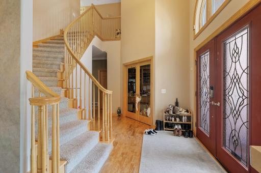 Impressive foyer upon entry with 19-foot soaring ceilings, & gleaming hardwood floors that gracefully extend throughout much of the main level. Nearby main level office, accentuated by glass French doors and custom built-ins providing ample storage.