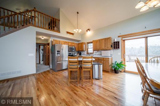 Kitchen has stainless steel appliances and patio door that leads to a spacious deck overlooking the private backyard.