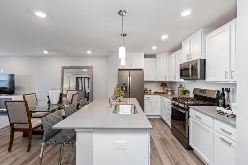 (Photo of decorated model, actual home's finishes may vary slightly) Enjoy plenty of seating at the kitchen island and dining area adjacent to the kitchen. Perfect for entertaining or having a family meal together.