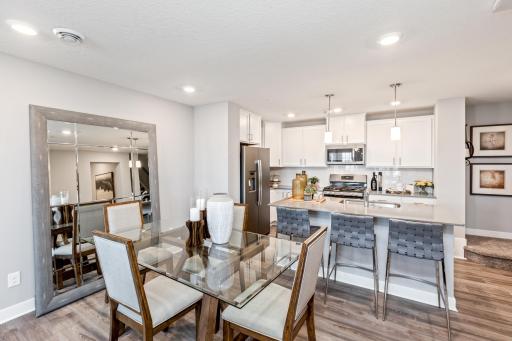 (Photo of decorated model, actual home's finishes may vary slightly) Soaked in natural sunlight, the homes eat-in dining room has ample space for a dining table located in the heart of the home.