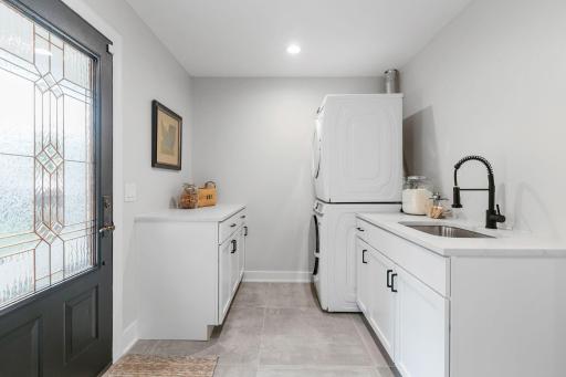 Laundry & Mud Room offers stackable washer/dryer, pocket door access to the kitchen and partial glass informal entry door