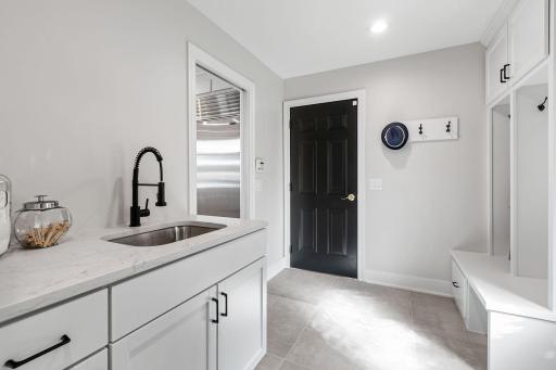 Built-in enameled lockers and cabinet with quartz countertop, modern tile flooring