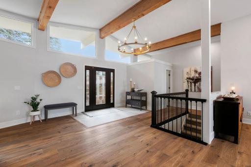 Open staircase with enameled posts and railing w/ dramatic chandelier