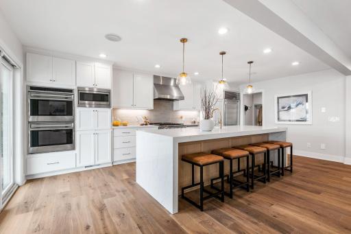 Quartz countertops with waterfall edges on center island and subway tile backsplash