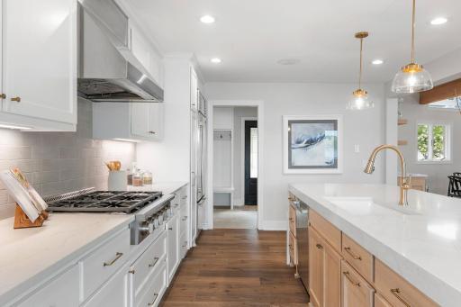Balanced combination of recessed lighting and brushed gold decorative pendants