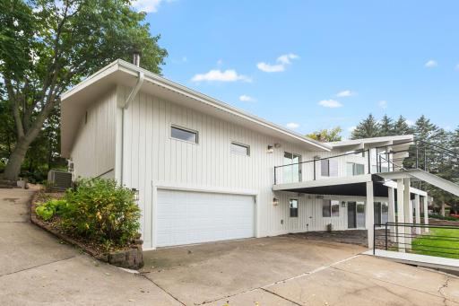 Concrete driveway leads to the heated lower 2+ car garage
