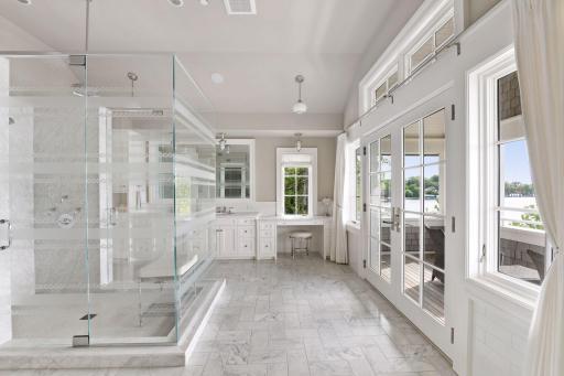 Carrara marble throughout, in-floor heat, glass shower with waterfall rain feature and double vanity and makeup table.