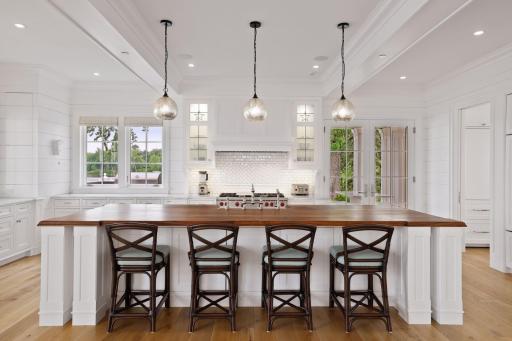 An expansive center island with striking walnut top, anchors the impressive kitchen.