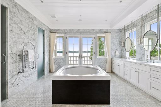 The luxurious spa bath features a steam shower, heated towel rack, shiplap ceiling detail, in-floor radiant heat, and water closet.