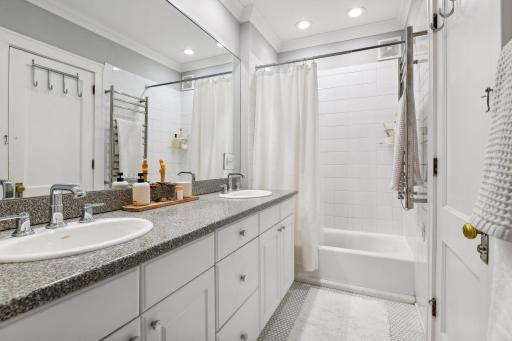 Large full bathroom with dual vanity and heated towel rack