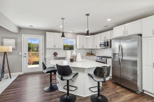 (Photo of a decorated model, actual homes finishes will vary) This kitchen features bar seating for casual meals from morning coffee to midnight snacks.