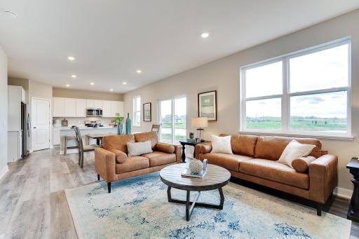 The view from this point helps re-define the open concept floor plan theory! Soaked in natural light, the family room is another spectacular use of space and offers incredible views out the back. Photo of model, colors & options will vary.