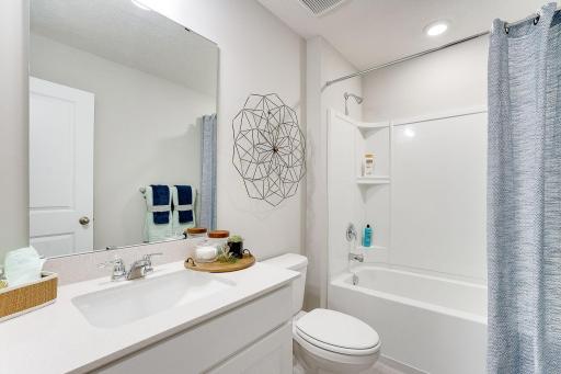 Convenience for the kids too, as the home's upper level guest bathroom features an extra long vanity and linen cabinet. Photo of model, colors & options will vary.
