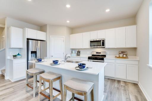 Smart & useful, kitchen is one of performance & boasts a set up which includes a stainless gas range, dishwasher & vented microwave - quartz counters, complimented by modern/clean look cabinets & much more! Photo of model, colors & options will vary