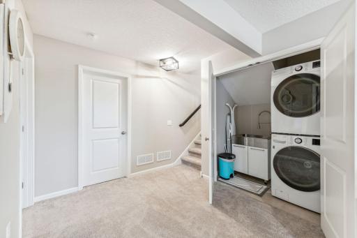 Lower level has new stackable washers and laundry sink.