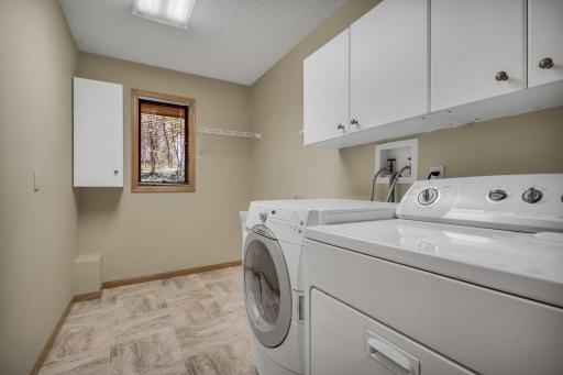 Gracious laundry with caibinetry, hanging/drying space, and utility sink are located near the kitchen, powder room, and mud room.
