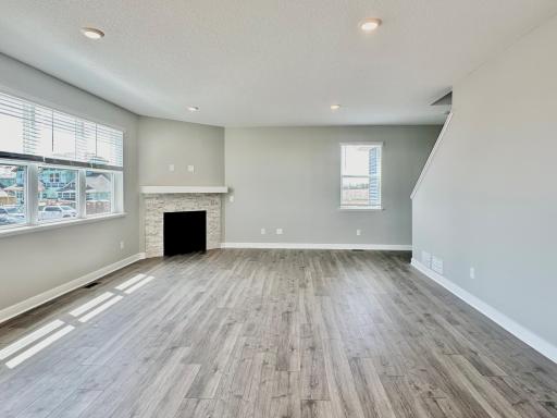 Open floor plan with hard floors throughout the living, dining, and kitchen.