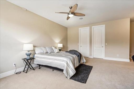 Fourth bedroom on upper level with dual closets and ceiling fan with light.