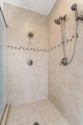 Custom tiled shower with dual shower heads.