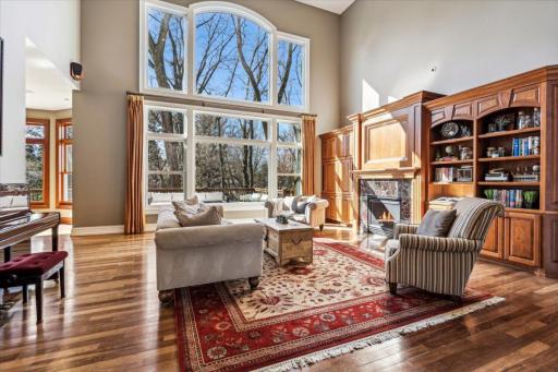 Sun-filled Gathering Room with Soaring Volume Ceilings, Fireplace and Palatial Windows overlooking the Creek.
