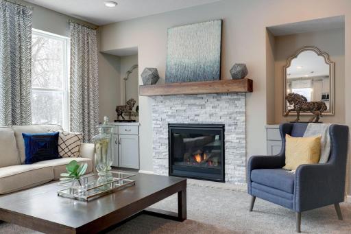 The family room is enhanced by a gas fireplace with stone surround - creating both warmth and style. Photo of model home, color and options will vary.