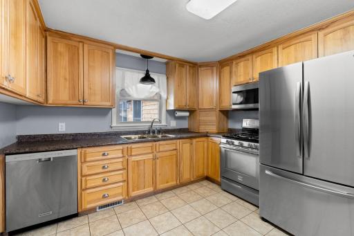 Spacious kitchen with lots of cabinets and newer stainless steel appliances.