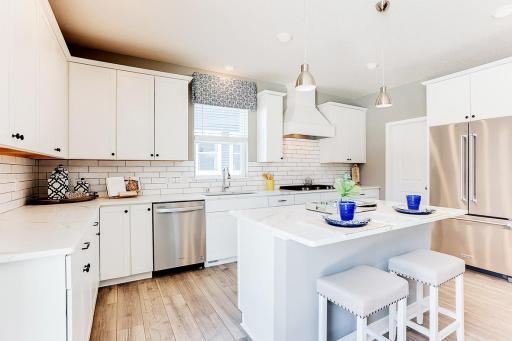 Our gourmet kitchen offers space and function with KitchenAid appliance and white cabinets. Actual home will have our Greyhound colored cabinets.