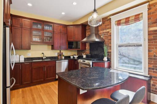Gourmet kitchen features cherry cabinets, granite countertops, and stainless steel appliances.