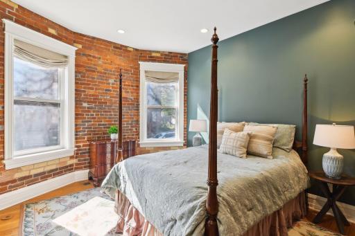 Primary bedroom boosts fresh paint and exposed brick.
