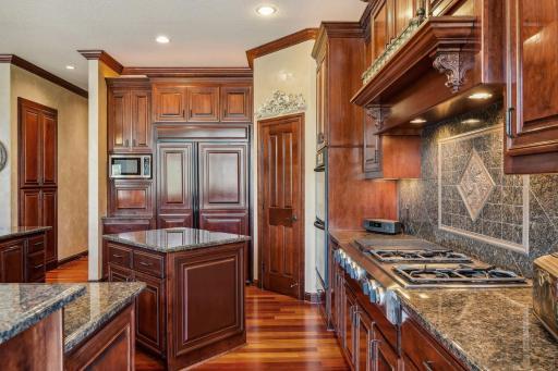 Custom cherry cabinets in the gourmet kitchen with built-in double oven, top of the line cooktop, and two center islands!