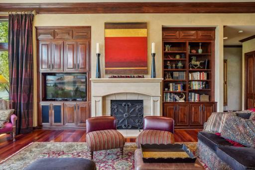 Limestone gas fireplace flanked by cherry custom cabinetry and Venetian plaster wall texture.