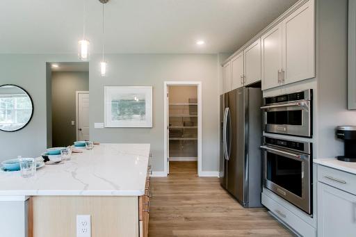 Another kitchen view looking toward the walk-in pantry. *Photo used is of a former model as an example on how to furnish.