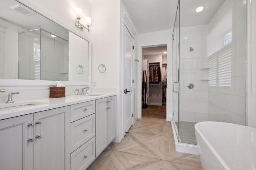 Primary bath features dual sinks, large walk-in shower, separate soaker tub, and walk-in closet